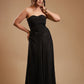 Woman in strapless black satin evening gown posing against beige background