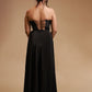 Woman in black strapless evening gown with lace-up back, studio backdrop
