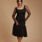 Woman modeling black mesh sleeve dress with tulle skirt and ankle strap heels in studio